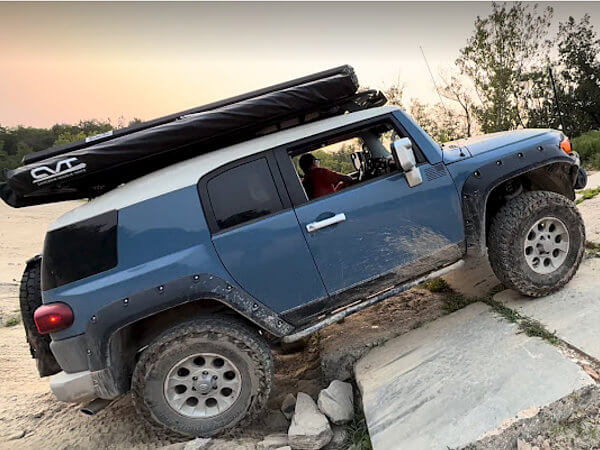 Blue Toyotal Land Cruiser going up an incline during the INLC Badlands Off Road Park Night Wheeling